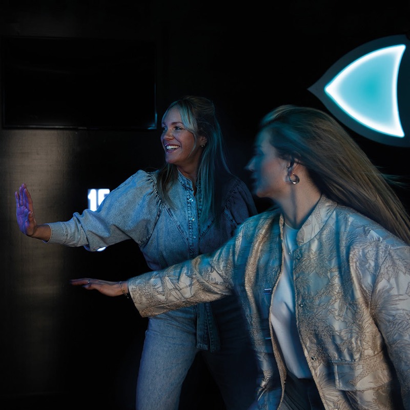 vrolijke groep vrienden juichend op de interactieve lichtvloer