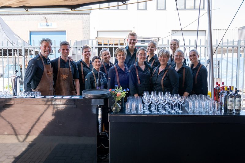 het team van Runderkamp achter de bar met glazen klaar voor de gasten